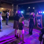 Scorcio di una festa con musica, balli e ospiti vestiti in stile country.