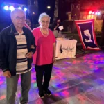 Scorcio di una festa con musica, balli e ospiti vestiti in stile country.