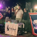 Scorcio di una festa con musica, balli e ospiti vestiti in stile country.